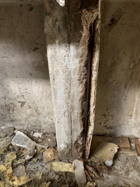 Skadad betongpelare med blottlagd armering